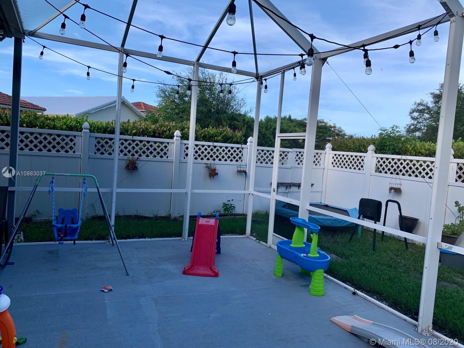 2329 Northeast 37th Road Homestead, FL 33033 - Photo 3 of 24 a view of a chair and table in the patio and a wooden fence