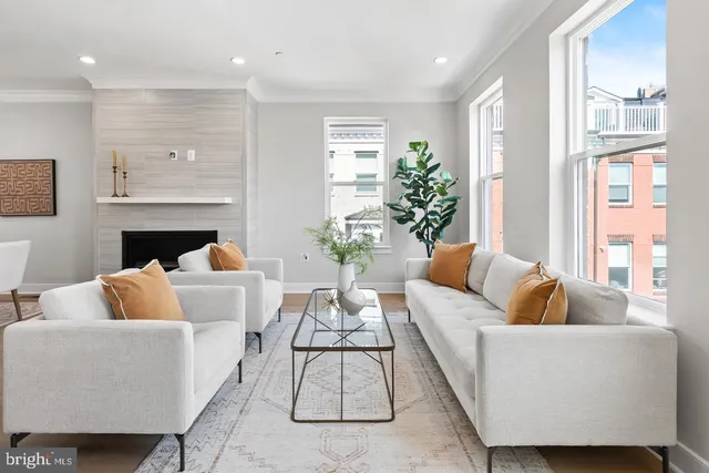 a living room with furniture kitchen view and a wooden floor