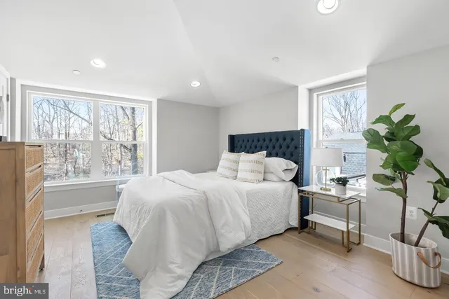 a bedroom with a large bed and a painting on the wall