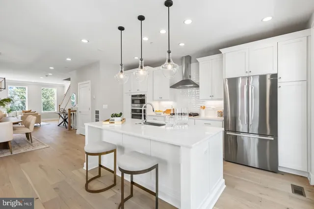 a kitchen with stainless steel appliances granite countertop a stove a sink and a wooden floors