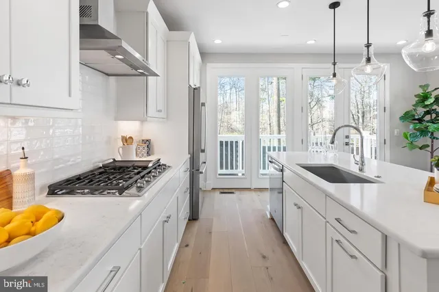 a kitchen with kitchen island a sink and a chandelier