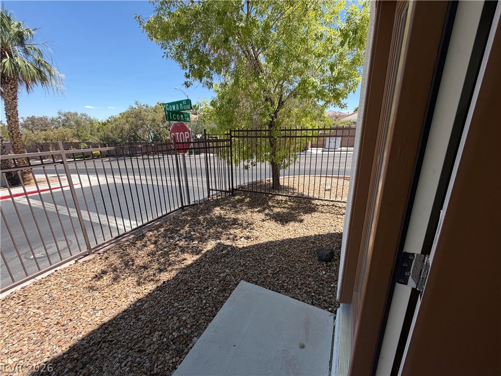 3610 Wireless Court Las Vegas, NV 89129 - Photo 12 of 15 A well-maintained street with mature trees and a protective fence defines the property boundary.