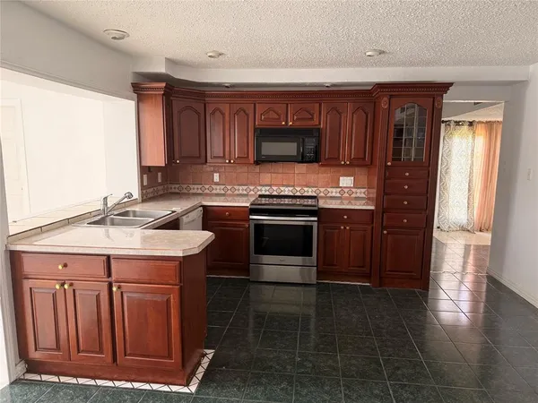 a kitchen with a stove a microwave and wooden cabinets