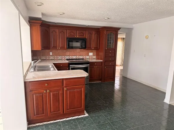 a kitchen with stainless steel appliances granite countertop a stove sink and cabinets