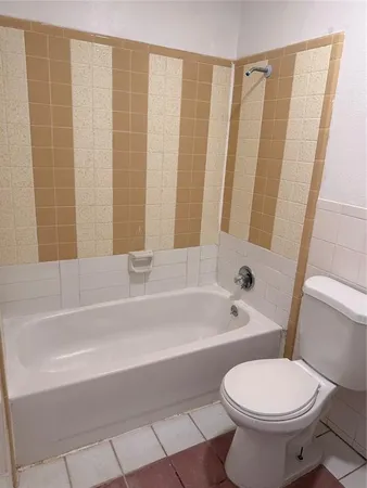 a white toilet sitting next to a bath tub