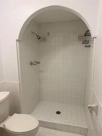 a bathroom with a toilet and a shower
