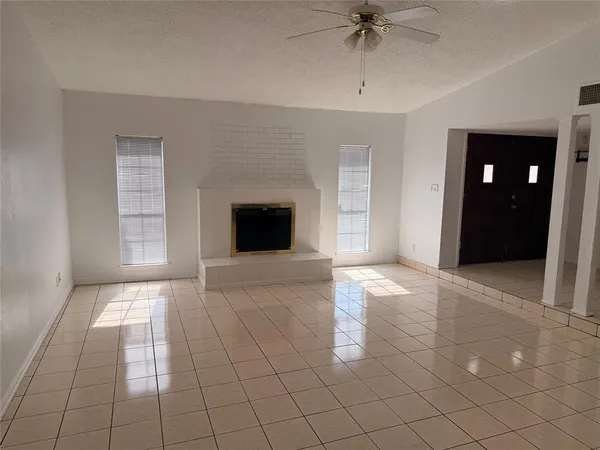a view of an empty room with a ceiling fan and window