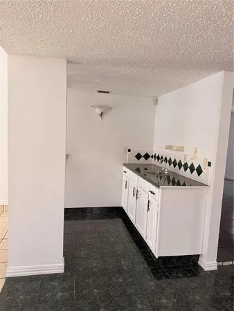 a kitchen with granite countertop white cabinets and white appliances