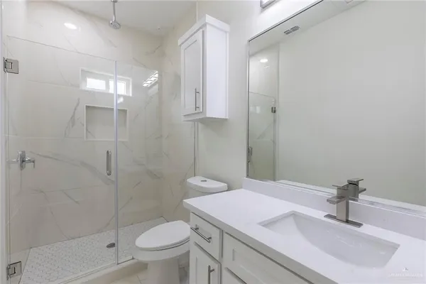 a bathroom with a sink a toilet and shower