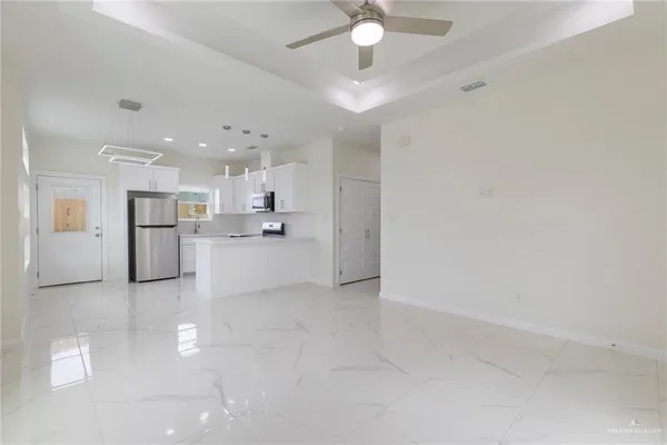 a view of a kitchen with refrigerator and a sink