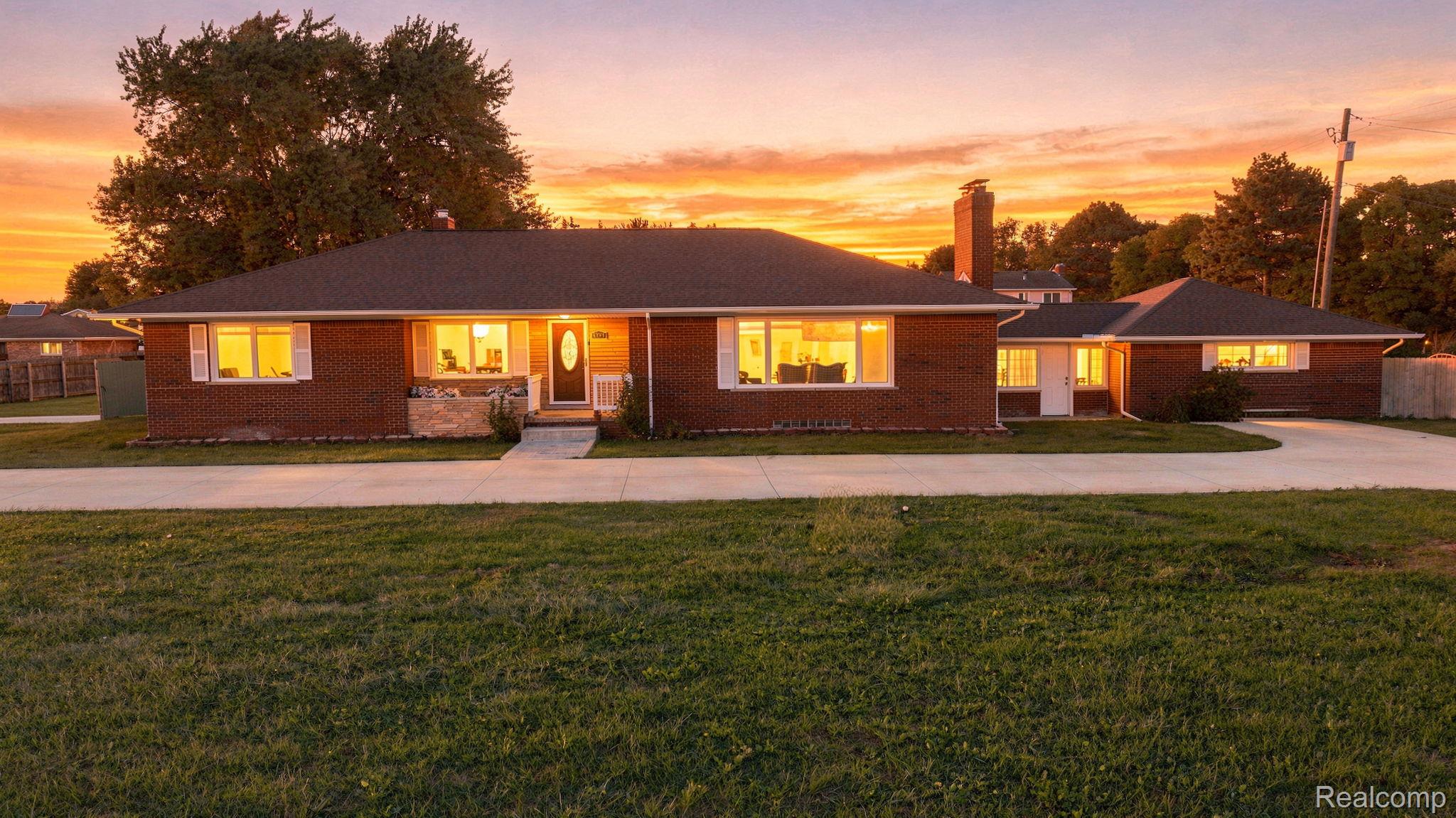 5353 18 Mile Road Sterling Heights, MI 48314 - Photo 1 of 53 Brick exterior with a dark-pitched roof, featuring a paved driveway and a front walkway leading to the entry