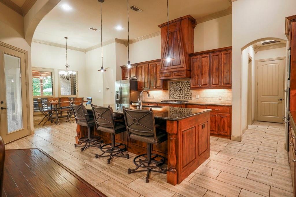 1387 Shadow Lakes Drive Wills Point, TX 75169 - Photo 10 of 33 a open kitchen with stainless steel appliances granite countertop a stove a sink dishwasher and a refrigerator with wooden cabinets