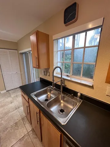 a kitchen with stainless steel appliances granite countertop a refrigerator a stove a sink and a microwave