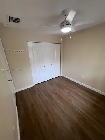 an empty room with a ceiling fan and a window