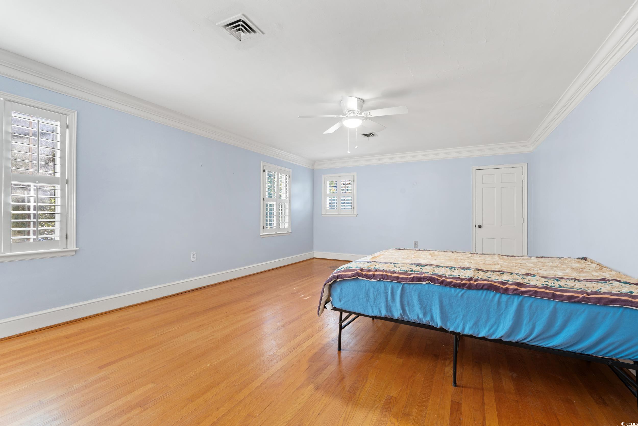 607 North Main Street Nichols, SC 29581 - Photo 14 of 39 Bedroom featuring wood finished floors, crown molding, and a ceiling fan