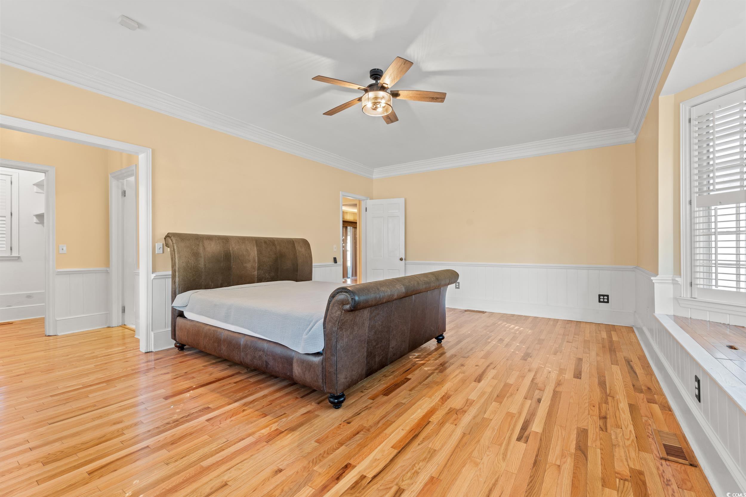 607 North Main Street Nichols, SC 29581 - Photo 25 of 39 Bedroom featuring a wainscoted wall, light wood-type flooring, ceiling fan, and crown molding