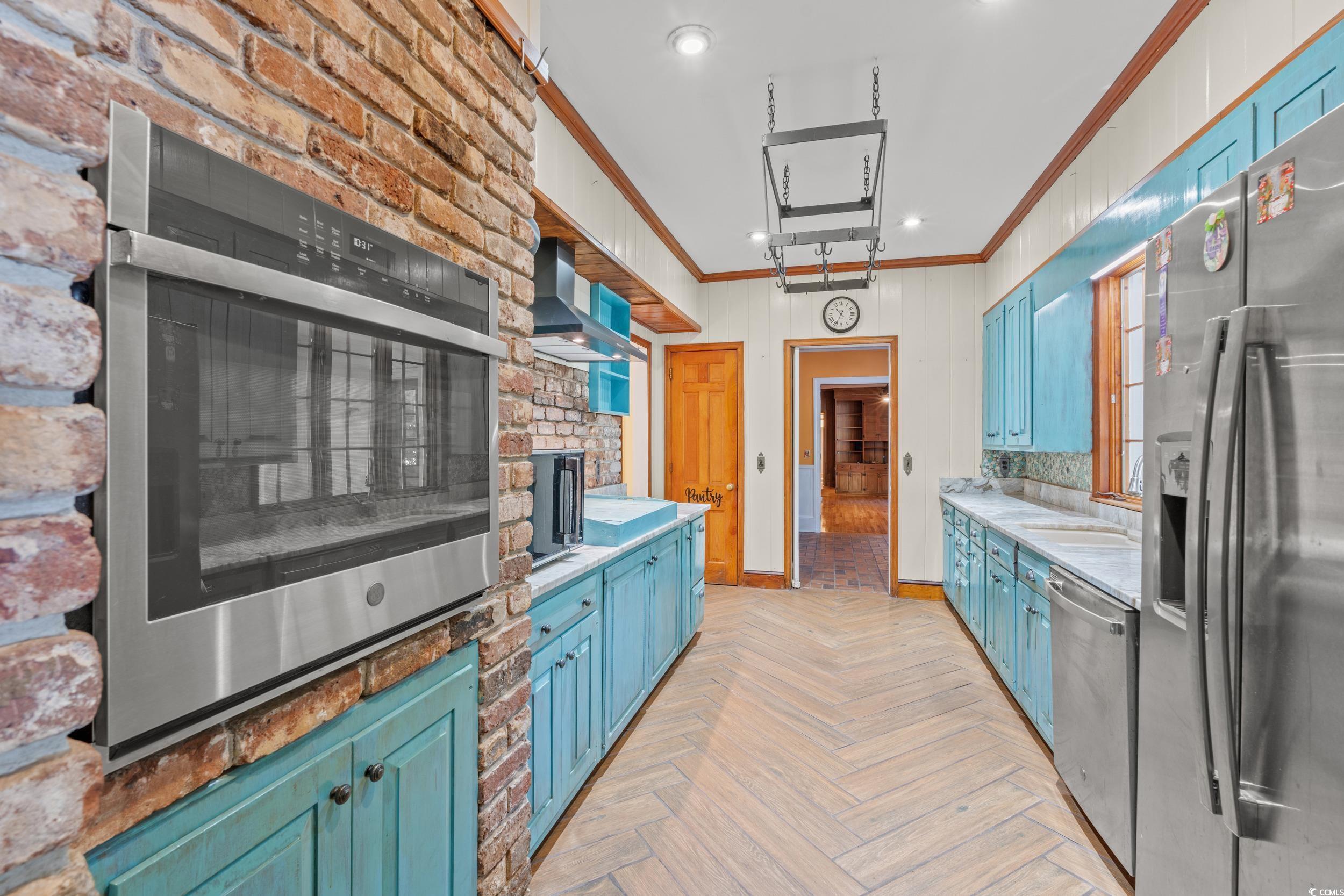 607 North Main Street Nichols, SC 29581 - Photo 10 of 39 Kitchen with blue cabinetry, stainless steel appliances, ornamental molding, wall chimney exhaust hood, and recessed lighting