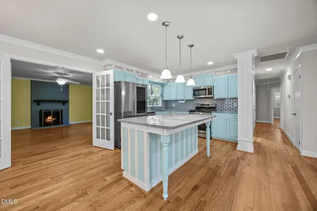 a kitchen with kitchen island a counter top space a sink stainless steel appliances and cabinets