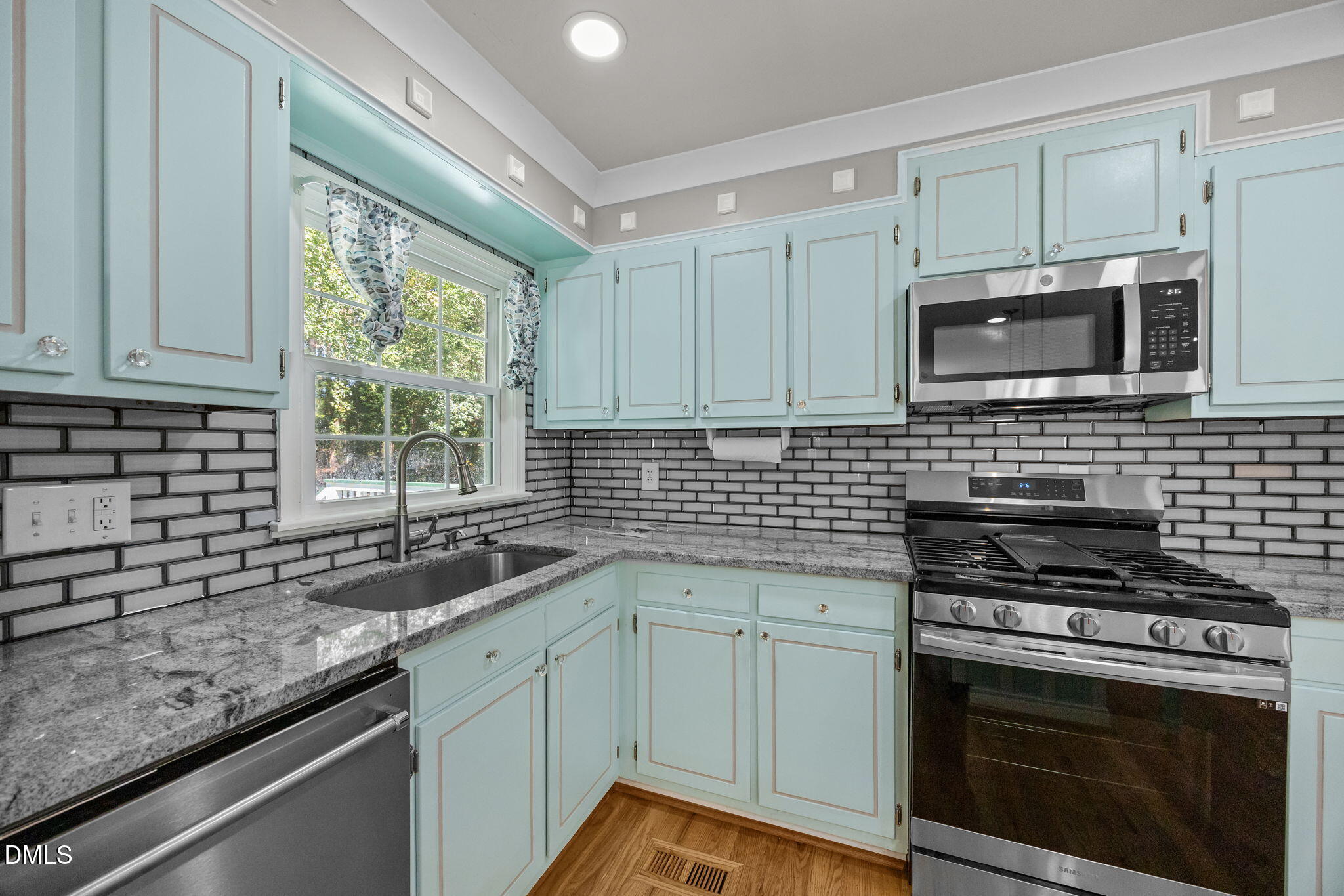 704 Brighton Road Durham, NC 27707 - Photo 8 of 25 a kitchen with granite countertop a sink stainless steel appliances and cabinets