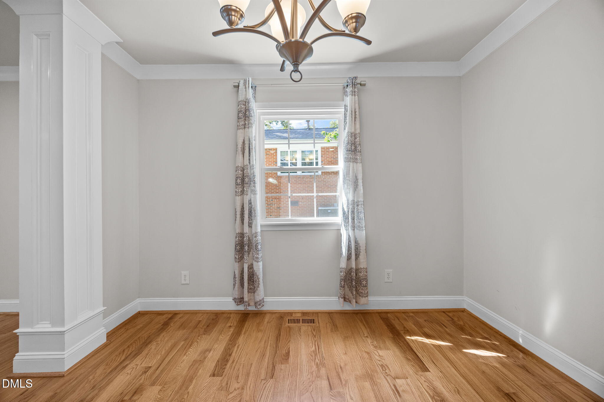 704 Brighton Road Durham, NC 27707 - Photo 9 of 23 a view of an empty room with wooden floor and a window