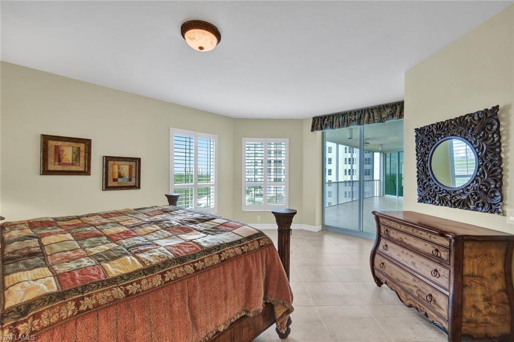 295 Grande Way, Unit 405 Naples, FL 34110 - Photo 16 of 40 a bedroom with a bed and a dresser next to a window