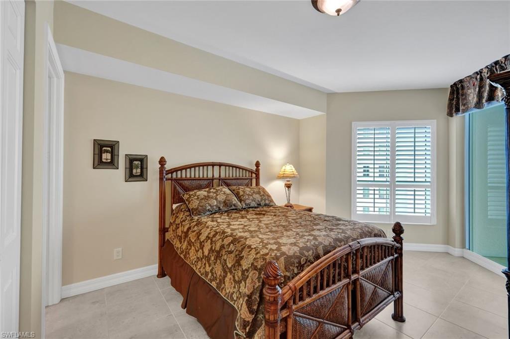 295 Grande Way, Unit 405 Naples, FL 34110 - Photo 19 of 40 a bedroom with a bed and a window
