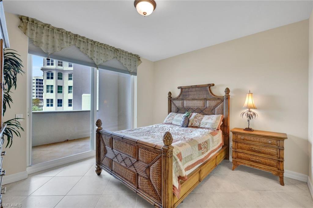 295 Grande Way, Unit 405 Naples, FL 34110 - Photo 21 of 40 a bedroom with a bed and a cabinets