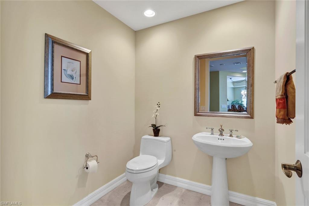 295 Grande Way, Unit 405 Naples, FL 34110 - Photo 23 of 40 a bathroom with a sink mirror and toilet