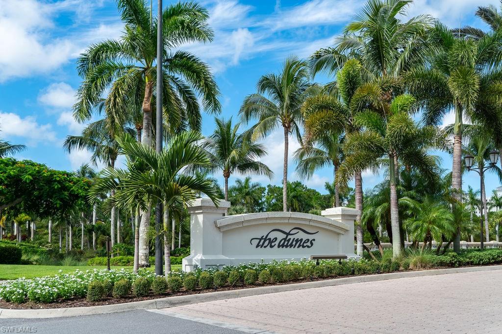 295 Grande Way, Unit 405 Naples, FL 34110 - Photo 33 of 40 a front view of a house with a garden and palm trees