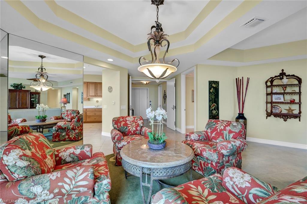 295 Grande Way, Unit 405 Naples, FL 34110 - Photo 8 of 40 a living room with furniture and a chandelier