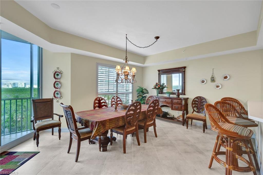 295 Grande Way, Unit 405 Naples, FL 34110 - Photo 10 of 40 a dining room with furniture a chandelier and window