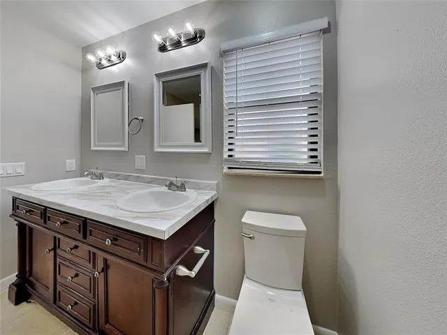 a bathroom with a sink a toilet and mirror