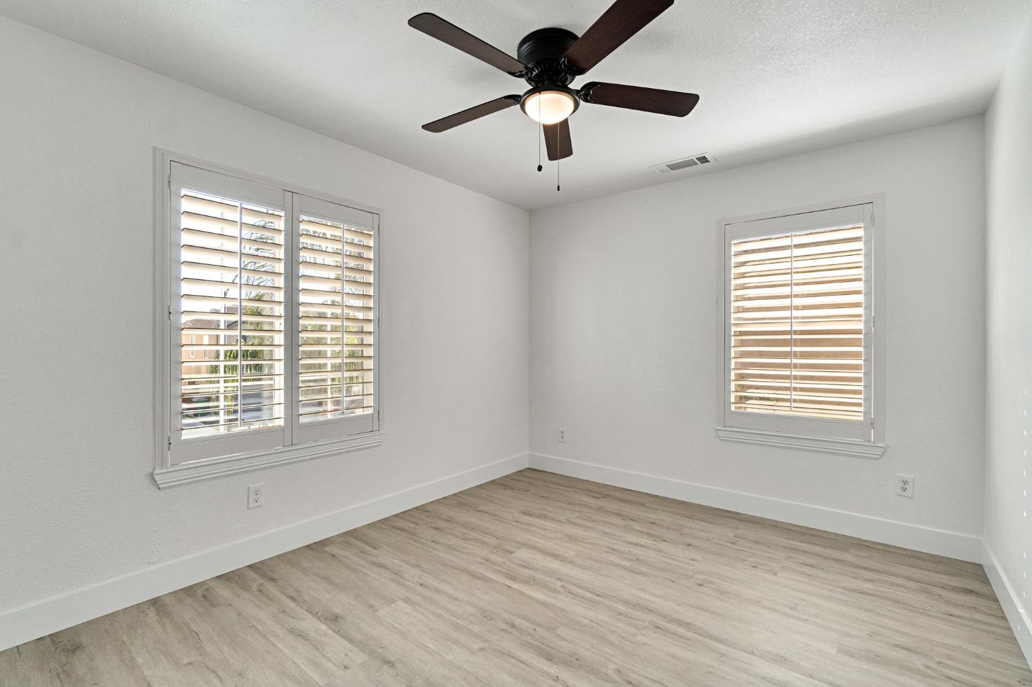 692 Blueberry Lane Madera, CA 93638 - Photo 23 of 44 a view of an empty room with wooden floor and a window