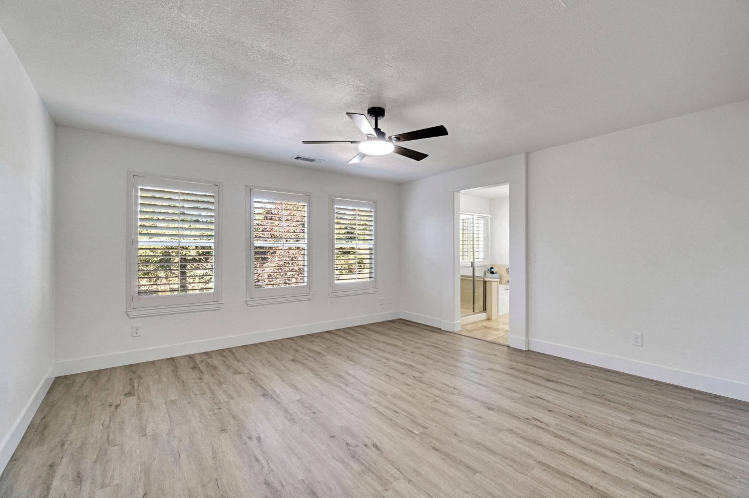 692 Blueberry Lane Madera, CA 93638 - Photo 29 of 44 a view of an empty room with a window and wooden floor