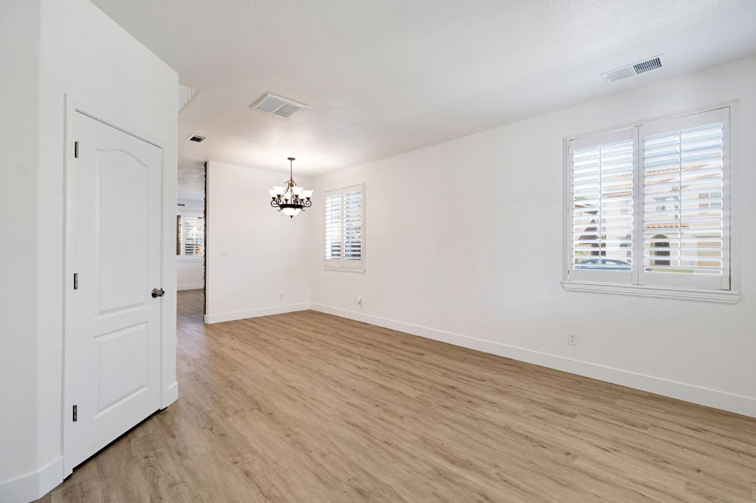 692 Blueberry Lane Madera, CA 93638 - Photo 3 of 44 an empty room with wooden floor cabinet and windows