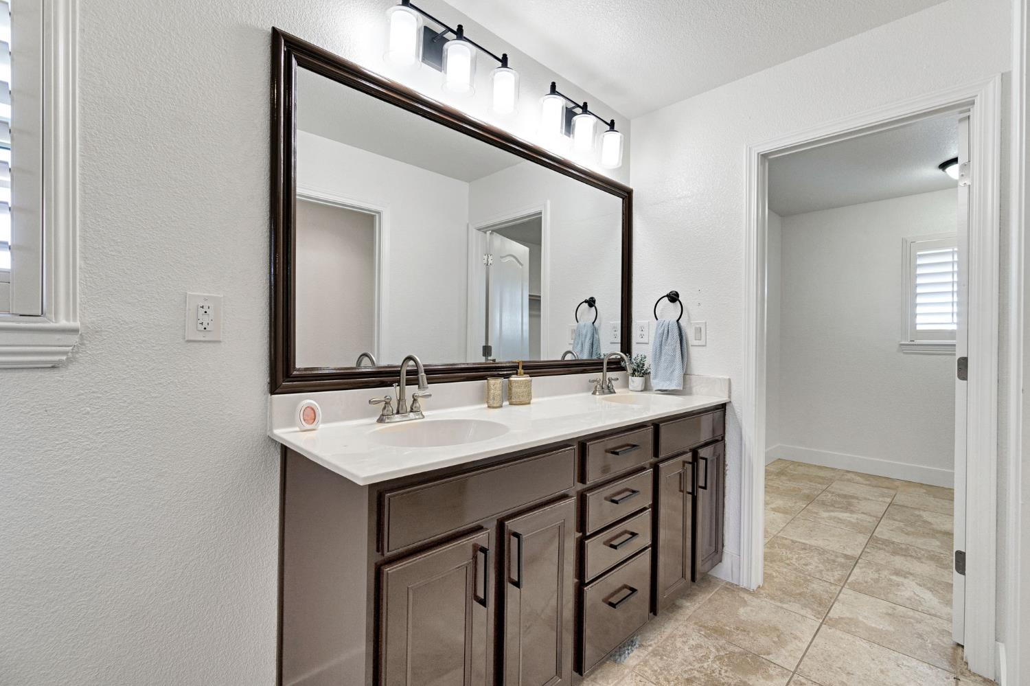 692 Blueberry Lane Madera, CA 93638 - Photo 32 of 44 a bathroom with a sink a vanity and a mirror
