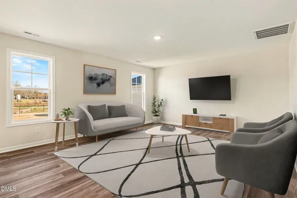 a living room with furniture a flat screen tv and a window