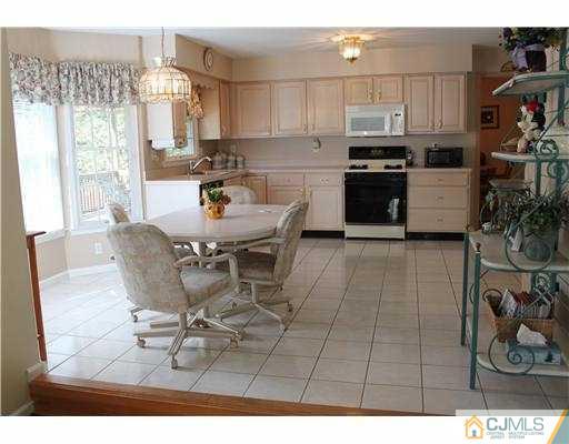 56 Pennington Road New Brunswick, NJ 08901 - Photo 6 of 20 a kitchen with stainless steel appliances kitchen island granite countertop a table chairs and a refrigerator