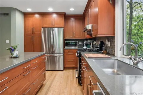 a kitchen with stainless steel appliances granite countertop a refrigerator and a sink