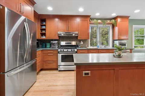 a kitchen with stainless steel appliances granite countertop a refrigerator a stove and a sink