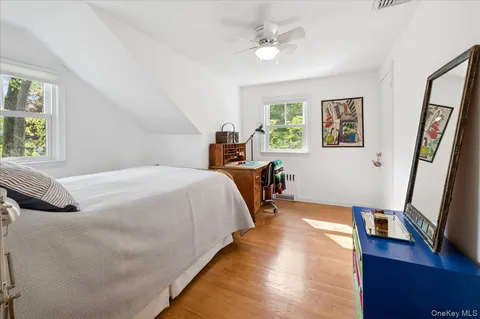 a bedroom with a bed a flat screen tv and a window