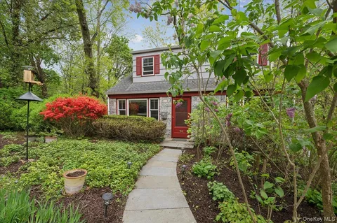 a front view of a house with plants and garden