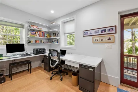 a view of a workspace with furniture and a window