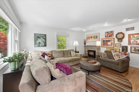 a living room with fireplace furniture and a large window