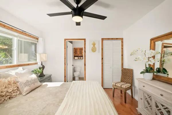 a bedroom with a bed dresser and a large window