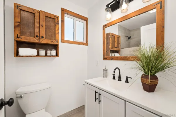 a bathroom with a sink a mirror and next to a window