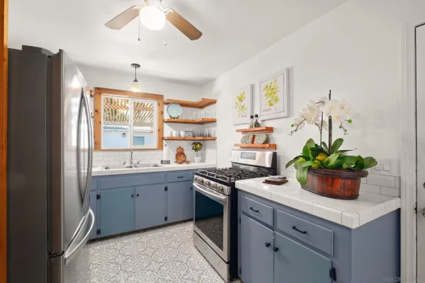 a kitchen with stainless steel appliances a sink a window and cabinets