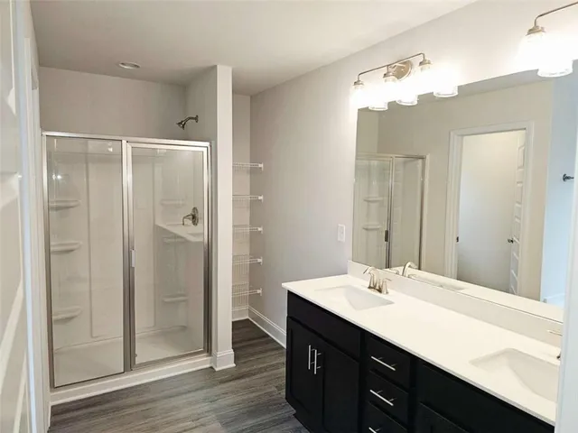 a bathroom with a double vanity sink mirror and shower