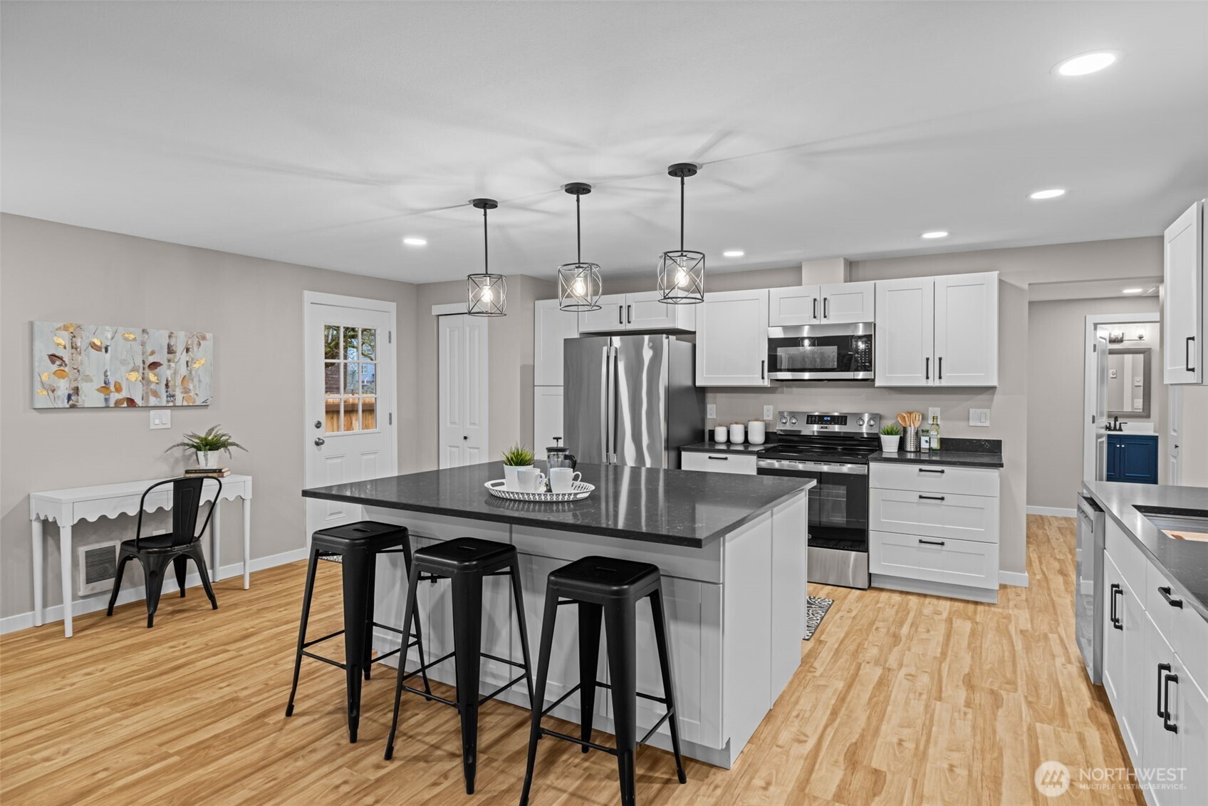 211 Taylor Street Snohomish, WA 98290 - Photo 4 of 24 a kitchen with stainless steel appliances kitchen island granite countertop a table chairs stove and white cabinets