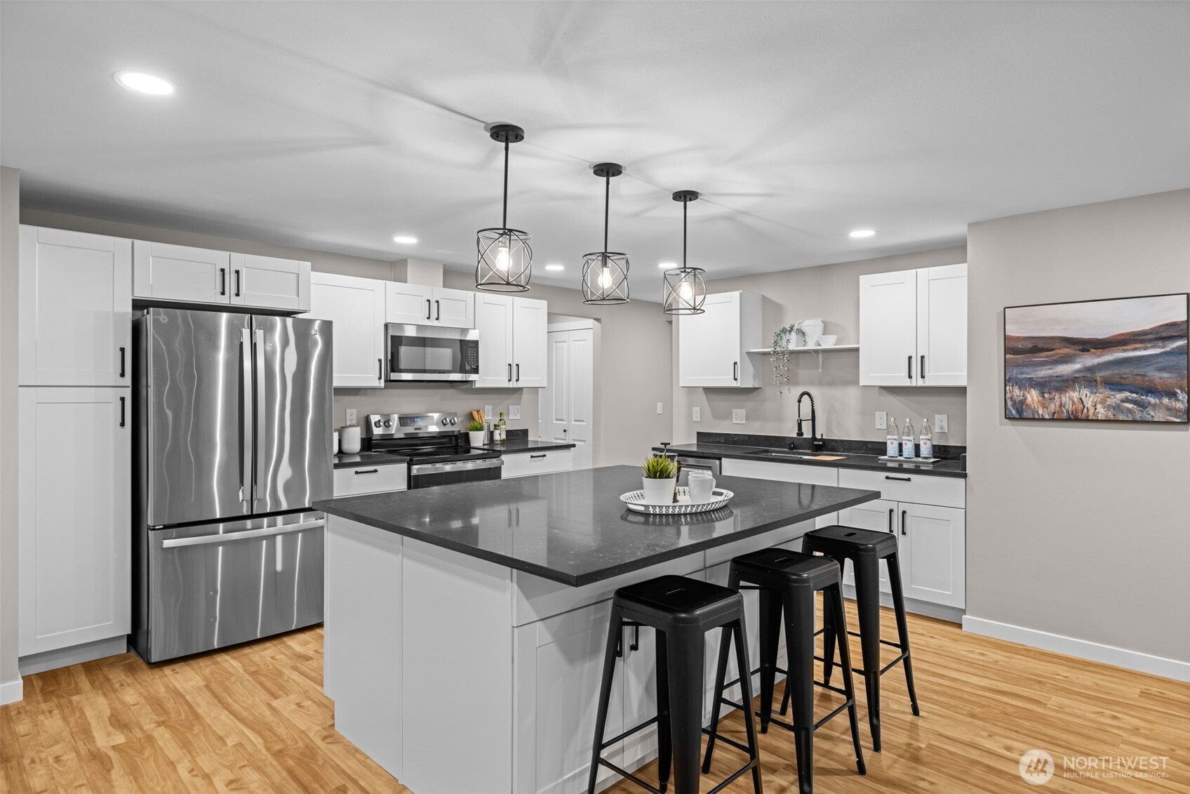 211 Taylor Street Snohomish, WA 98290 - Photo 6 of 24 a kitchen with stainless steel appliances granite countertop a refrigerator a stove a sink a dining table and chairs with wooden floor